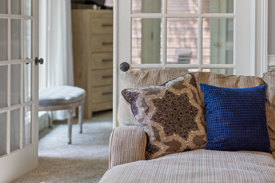 GLOW's thoughtful in-home touches that enhance guest comfort and contribute to a five-star short-term rental experience. Couch with a pillow.