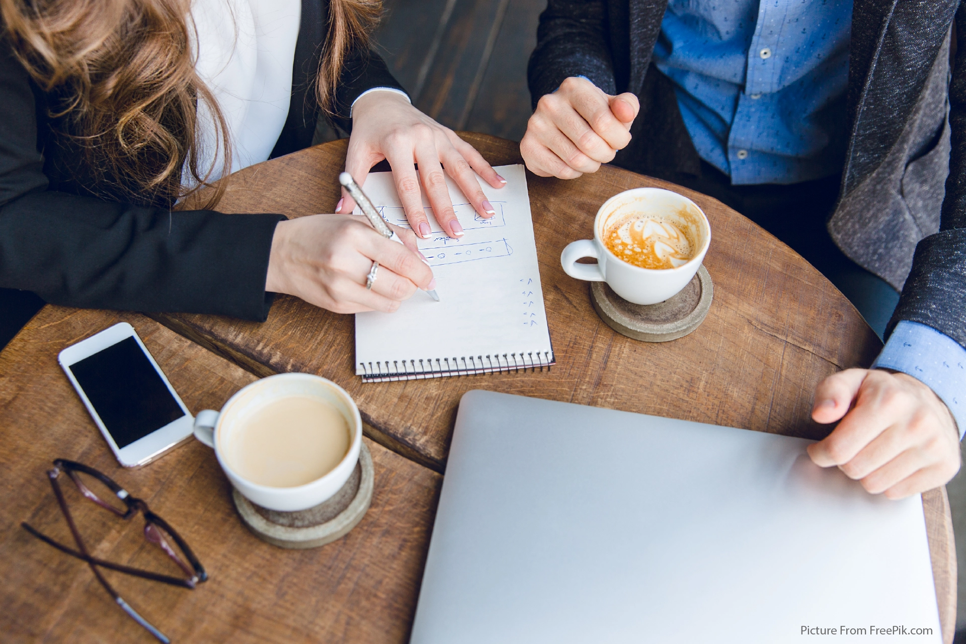 GLOW | Knowing your numbers, 2 individuals working on spreadsheets at a coffee shop
